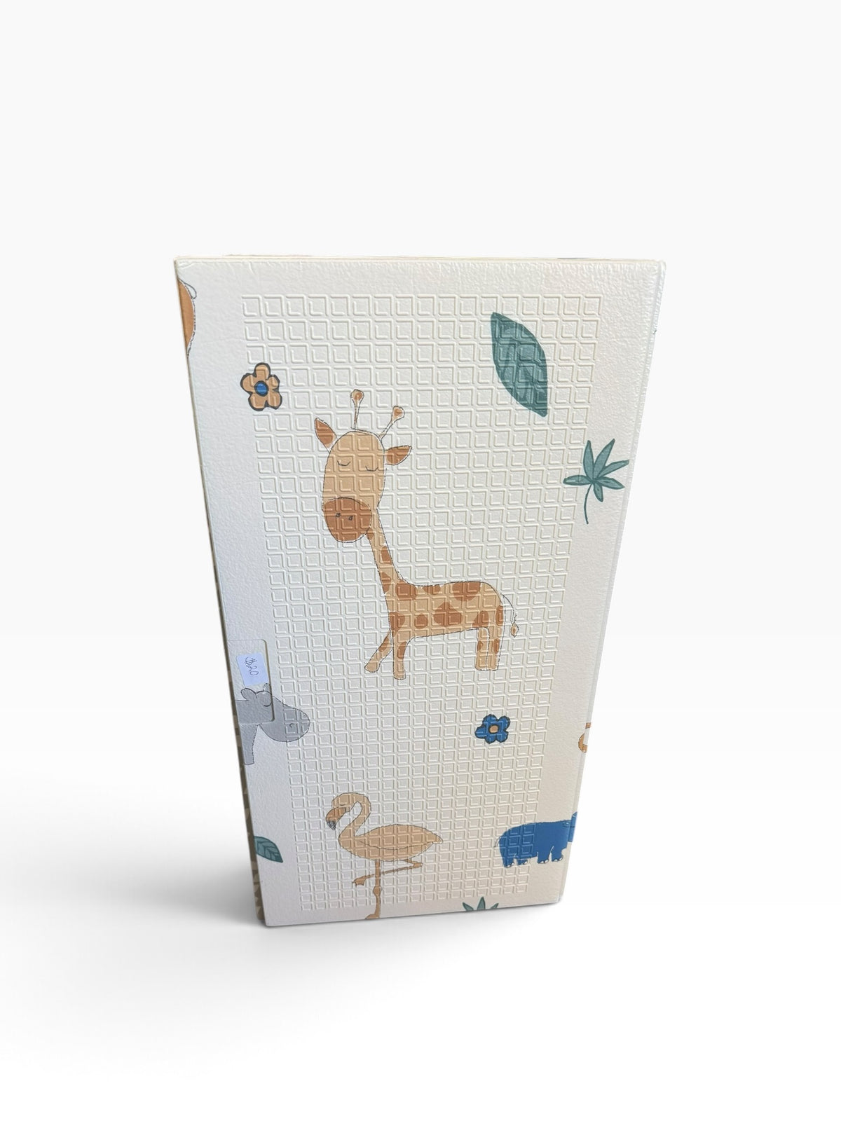 Folded cream-colored play mat with giraffe and bird illustrations
